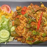 Лагман: лапша с овощами и мясом на тарелке рядом с салатом
